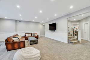 Downstairs family room with recessed lighting, carpet and a wainscoting