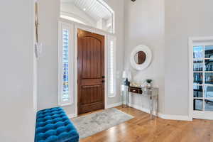 Foyer entrance with hardwood floors and a high ceiling