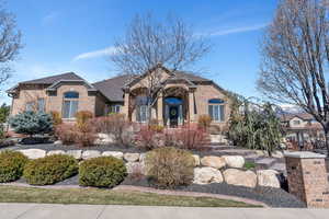 French provincial home with brick siding and a shingled roof