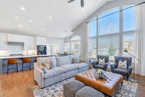 Great room  featuring vaulted ceiling, hardwood flooring, recessed lighting, and a ceiling fan