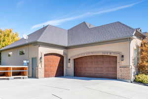 View of home's exterior with an attached garage, stucco siding, brick siding, and concrete driveway