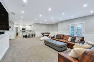 Family  room with wainscoting, outside entrance, carpet, and recessed lighting