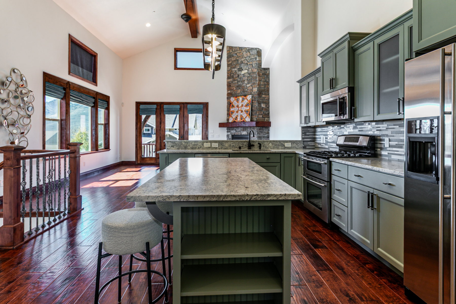 Open-concept kitchen with sage green cabinetry and a large central island