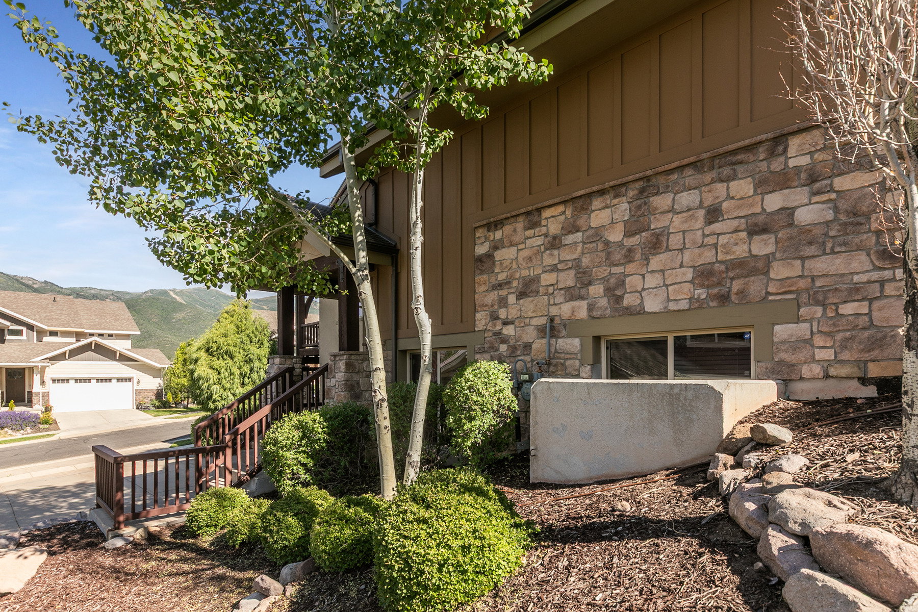 Exterior featuring board and batten siding, stone facade, and a covered porch