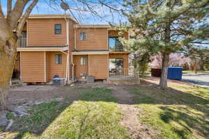 Rear view of house with a balcony and a yard