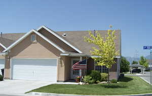 Single story home featuring stucco siding, a front lawn, concrete driveway, an attached garage, and roof with shingles