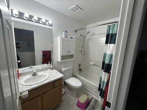Full bathroom featuring vanity, a textured ceiling, and shower / bath combo