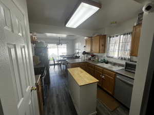 Kitchen featuring butcher block counters, wood finish cabinetry, a peninsula, and stainless steel appliances