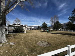 View of yard featuring a playground, a mountain view, and a patio