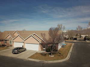 View of front of house with a residential view, an attached garage, concrete driveway, and stucco siding
