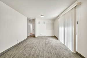 Carpeted spare room featuring baseboards