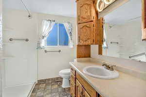 Bathroom with a walk in shower, floors, and vanity