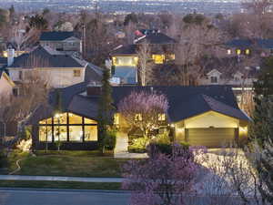 Traditional-style house featuring an attached garage, driveway, roof with shingles, and a front yard