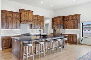 Kitchen featuring wood finish cabinetry, backsplash, a breakfast bar, and recessed lighting