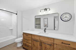Full bath featuring vanity, light tile patterned floors, and shower / bathtub combination
