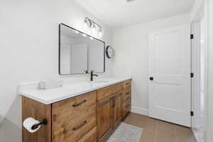 Bathroom with light tile patterned floors and vanity
