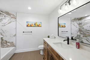 Full bath featuring vanity, recessed lighting, and a combined bath / shower with marble appearance