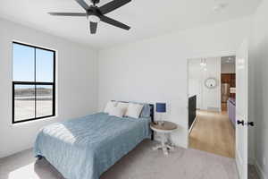 Bedroom with light carpet, high quality fridge, and a ceiling fan