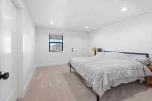 Bedroom with light carpet and recessed lighting