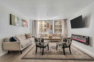 Living area featuring a glass covered fireplace and light wood-type flooring