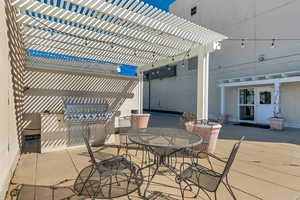 View of patio with outdoor dining area, a pergola, and grilling area