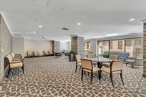 Dining area with dark colored carpet and recessed lighting
