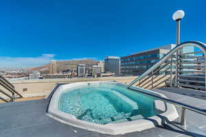 View of pool featuring patio surround, a mountain view, a city view, and an outdoor hot tub