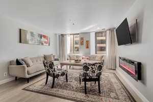 Living area with baseboards and light wood finished floors