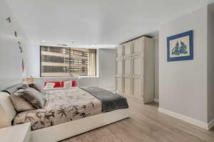 Bedroom featuring light wood finished floors and a closet
