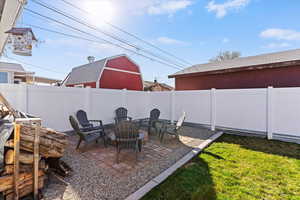 Fenced backyard with a patio area and a fire pit