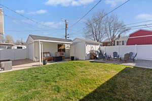 Rear view of house with a patio area, an outbuilding, a fenced backyard, and an outdoor hangout area