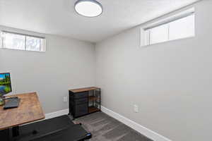 Unfurnished office with dark carpet and a textured ceiling