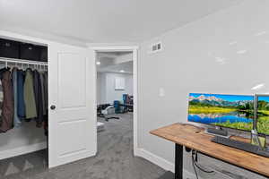 Carpeted office space featuring baseboards
