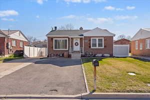 Bungalow-style home with brick siding and a chimney