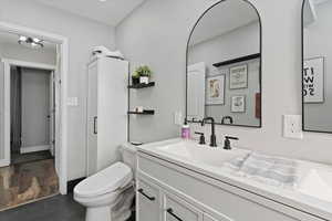 Full bath with vanity and dark wood finished floors