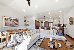 Living area with ceiling fan, wood finished floors, lofted ceiling, and recessed lighting