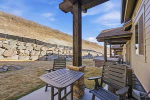 View of patio / terrace with a mountain view, a hot tub, and outdoor dining space