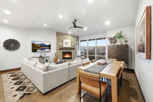 Living area featuring a fireplace, light wood-style flooring, a ceiling fan, lofted ceiling, and recessed lighting