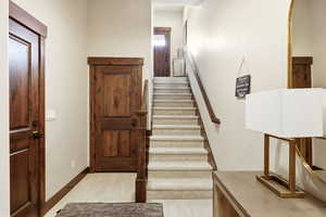 Stairs with wood finished floors and baseboards