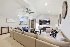 Living room featuring a ceiling fan, lofted ceiling, light colored carpet, and recessed lighting
