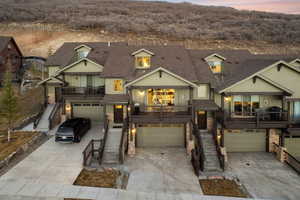Craftsman-style home with stone siding, an attached garage, and concrete driveway
