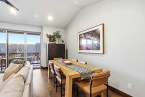 Dining space with lofted ceiling, wood finished floors, and a ceiling fan