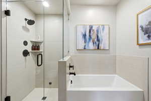 Bathroom featuring a garden tub and a shower stall