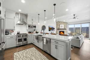 Kitchen featuring a peninsula, a fireplace, tasteful backsplash, high end appliances, and open floor plan