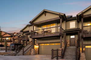 View of front of property featuring a balcony, board and batten siding, a garage, and driveway