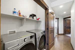Laundry area featuring light wood-type flooring, recessed lighting, and washer and clothes dryer