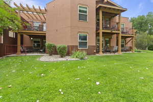 Back of property with a patio, stucco siding, a yard, and a pergola