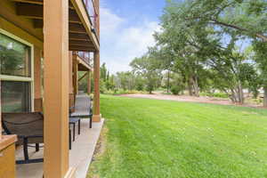 View of grassy yard featuring a patio area