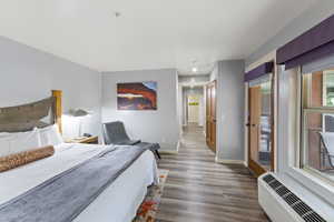 Bedroom with access to exterior and dark wood-style floors