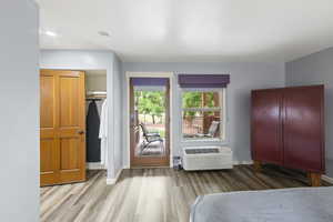 Bedroom featuring wood finished floors, a closet, and access to outside